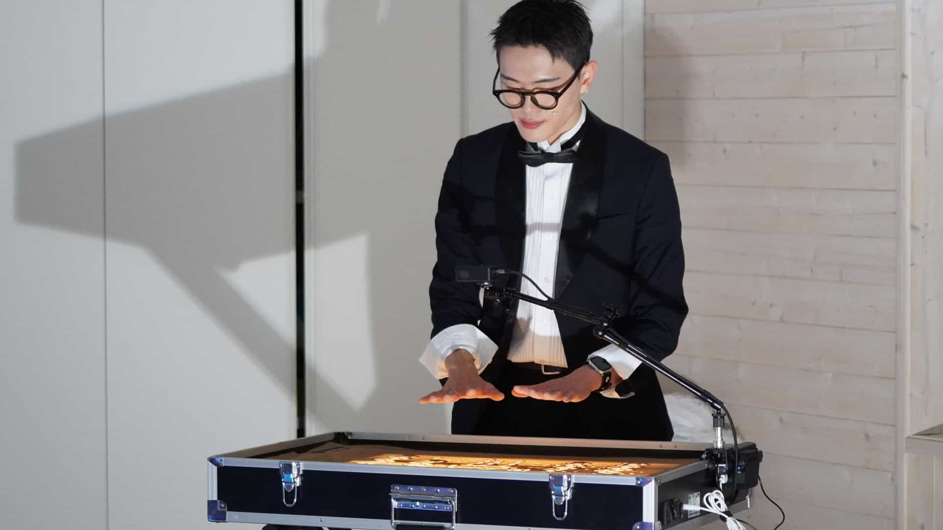 샌드아트 공연자가 손끝으로 작품을 완성하는 장면
